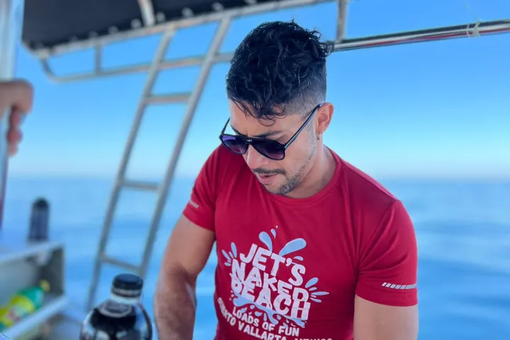 a man standing next to a body of water